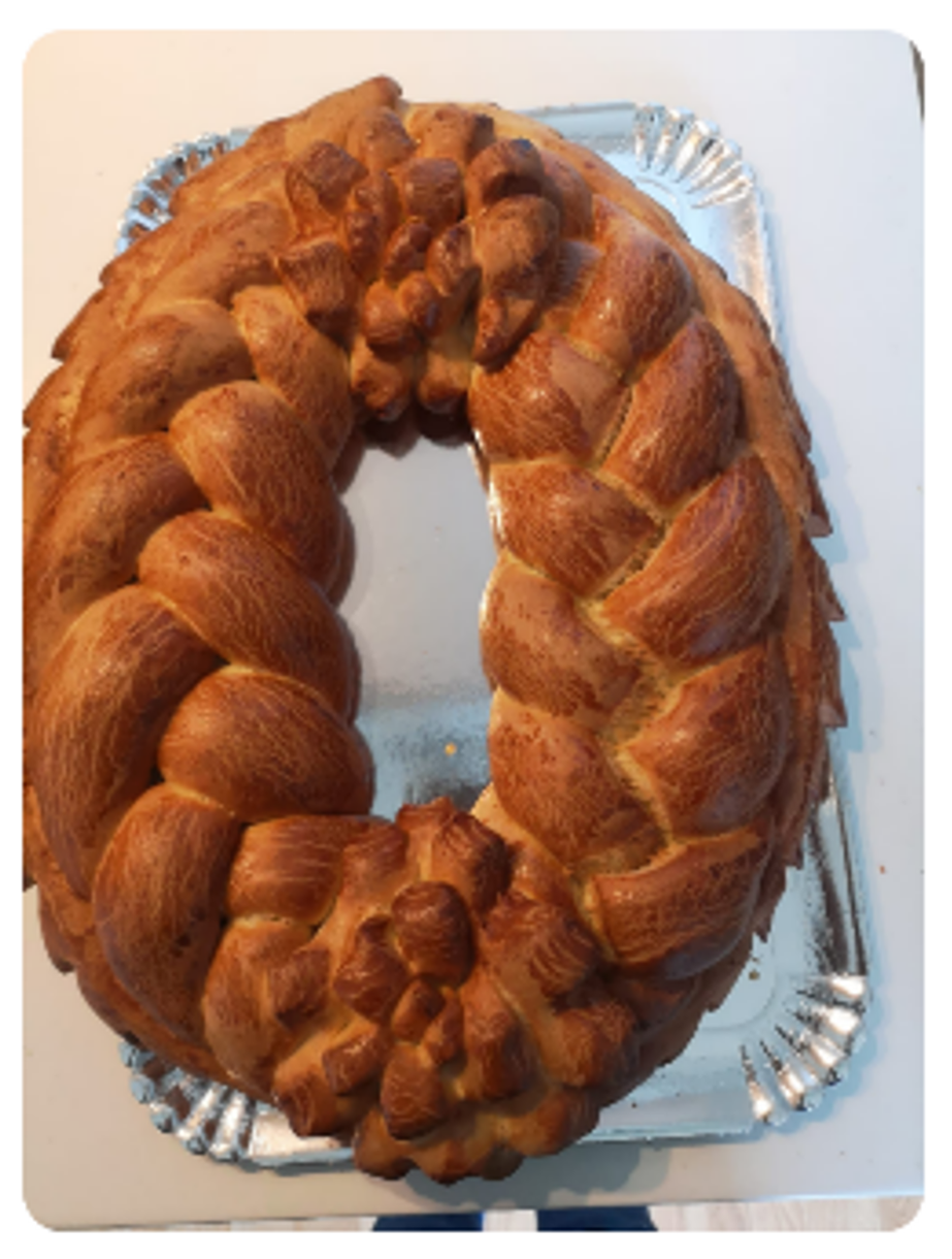 Couronne de pain doré tressée sur un plateau en argent.