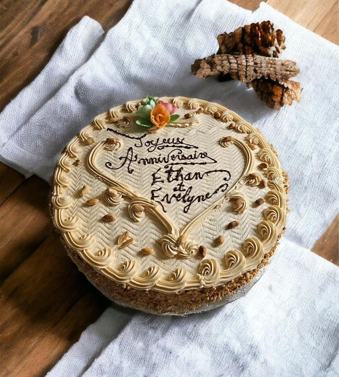 Gâteau rond avec glaçage et décorations beiges, un tissu blanc en dessous.