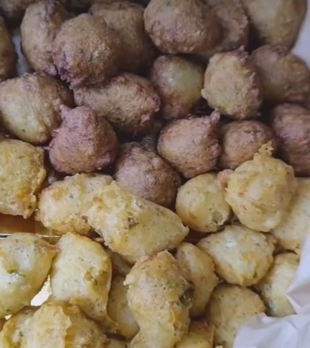 Beignets dorés et bruns frits empilés ensemble.