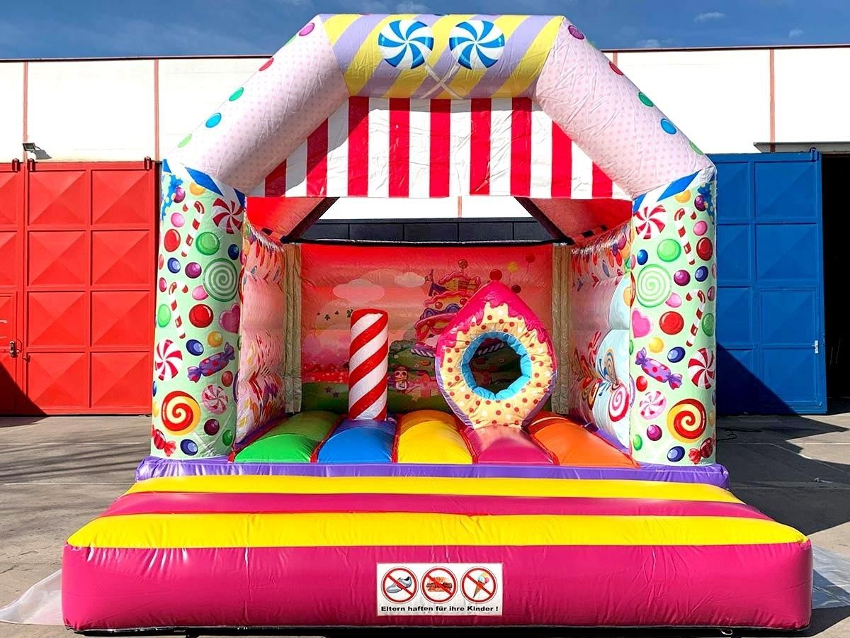 Open-Air-Festival mit Bühne, Hüpfburgen, Essensständen und einer Menschenmenge auf einem Stadtplatz.