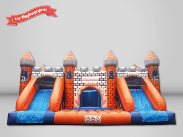 Der Hüpfburgexperte sehr große orange-blaue Hüpfburg mit zwei Rutschen, im Burg Design.