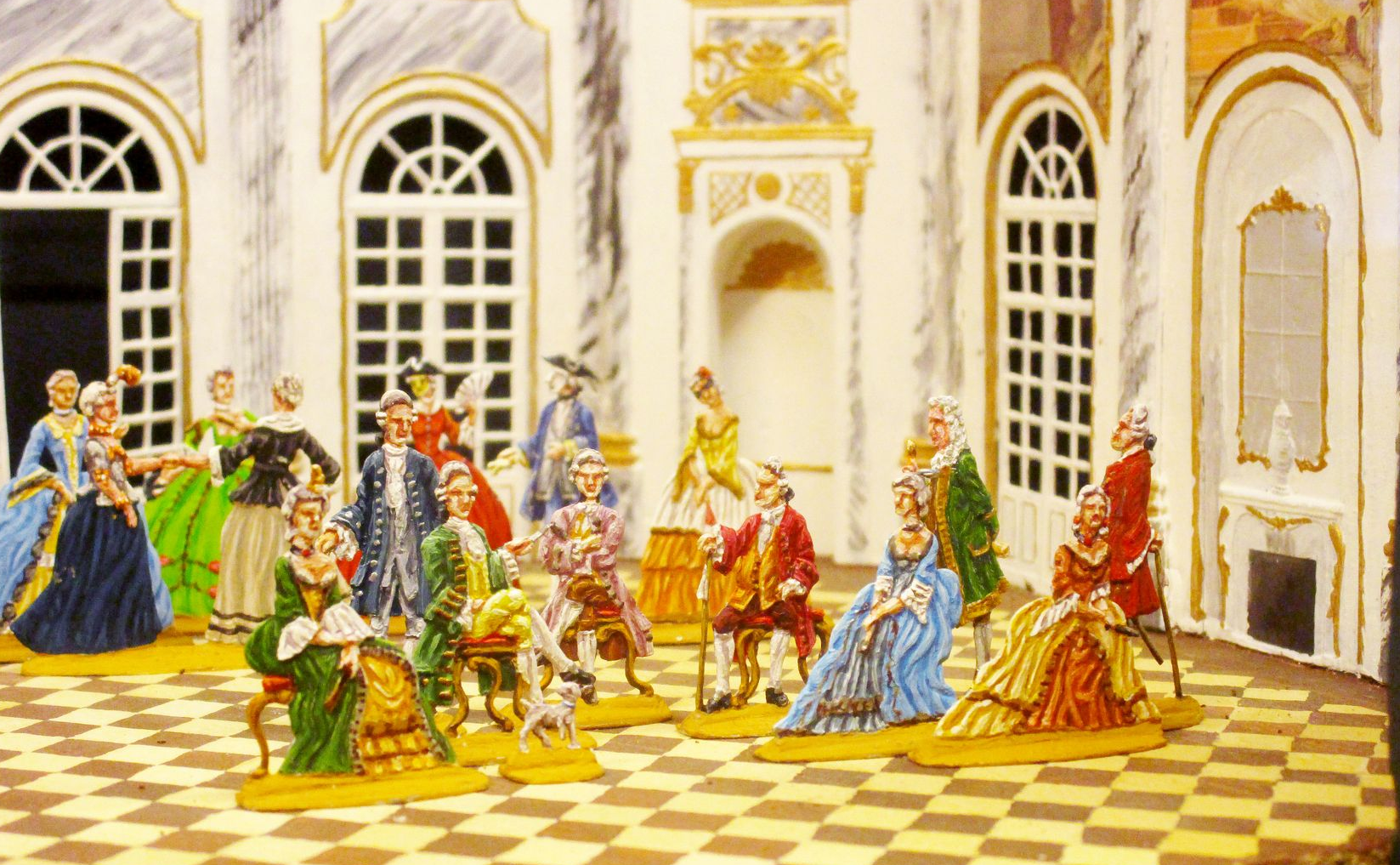 Bild mit Zinnfiguren im Gewand des Barock in einem Saal.