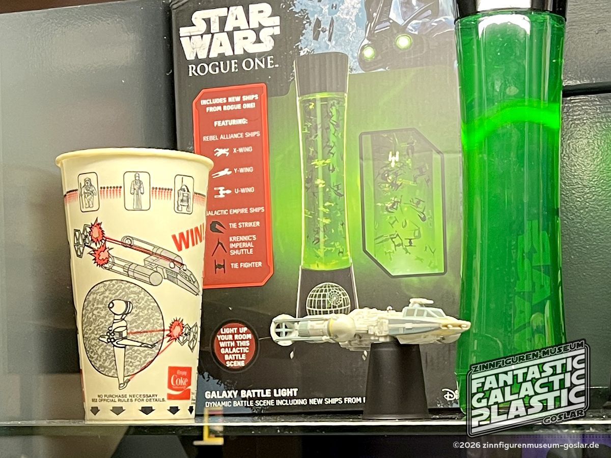 Coca-Cola Pappbecher für Mc Donald's mit Preisausschreiben (USA, 1985), Galaxy Battle Light (Lavalampen-Variante) von Paladone (2016) und BTL-A4 Ornament (Christbaumschmuck) mit Soundeffekten von Hallmark (USA, 2015).