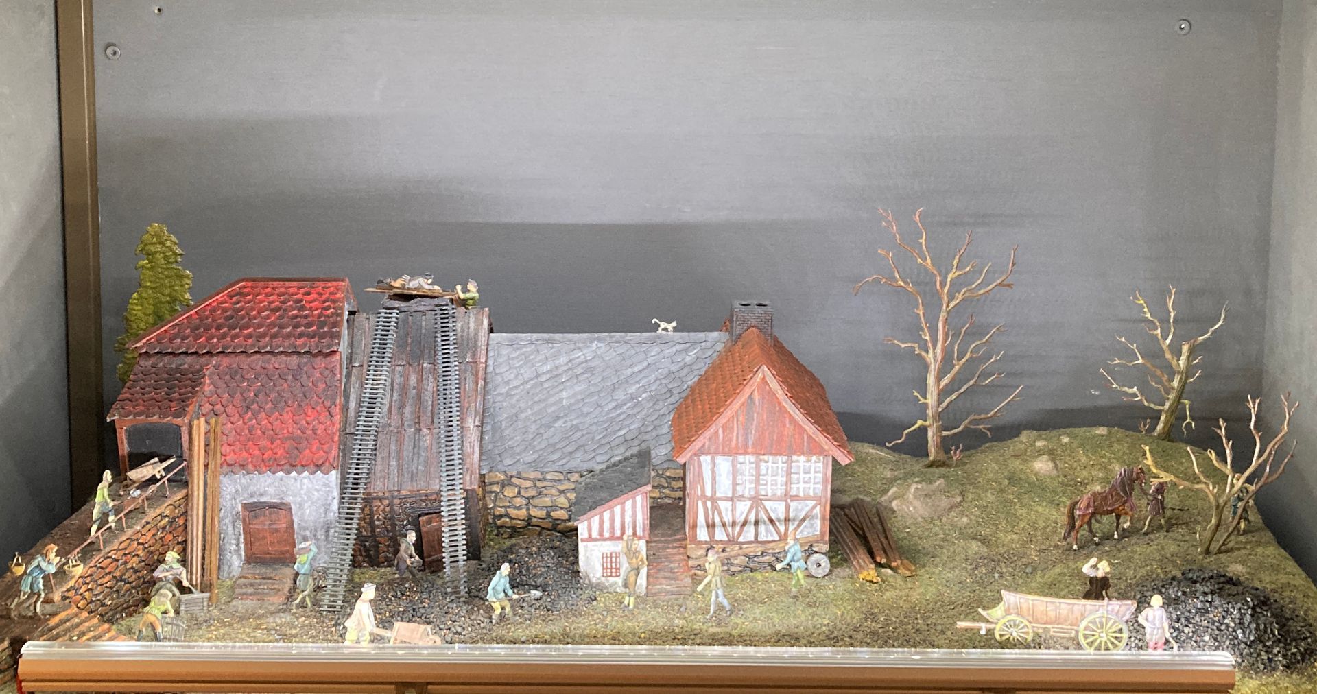 Ein Haus mit Störchen auf dem Dach und arbeitende Personen.