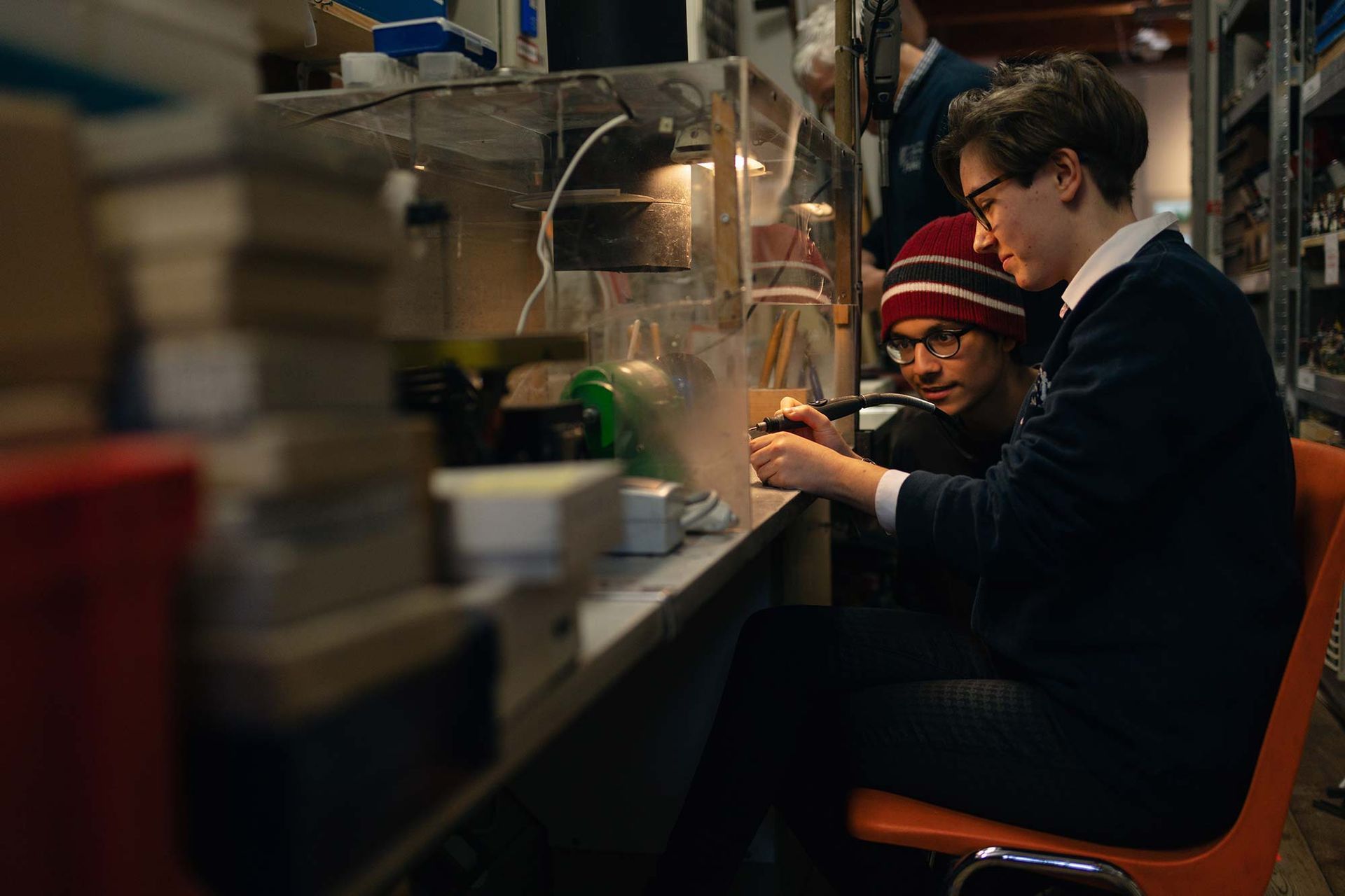 Zwei Männer sitzen an einem Tisch und arbeiten an einem Computer.