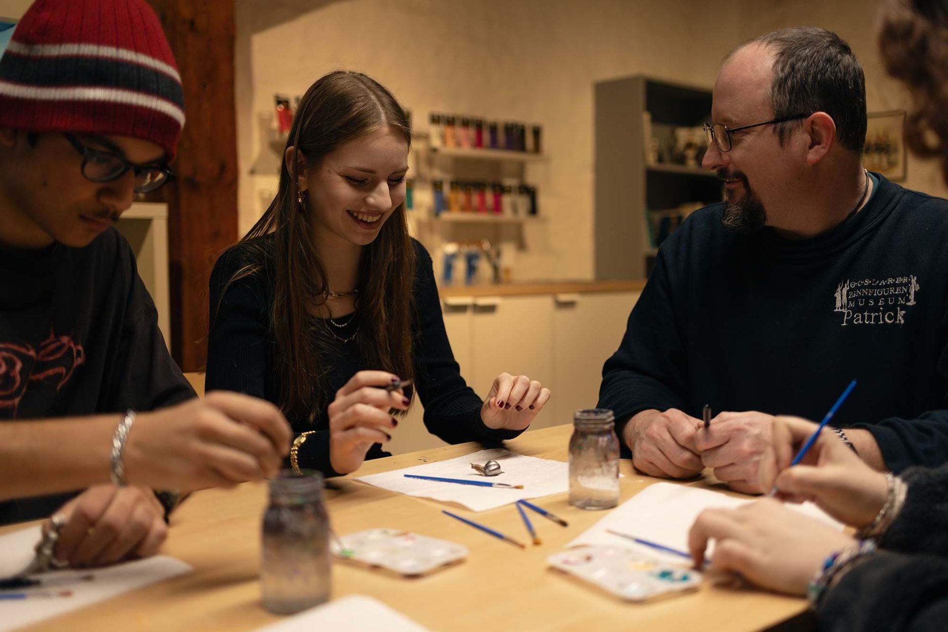Eine Gruppe von Leuten sitzt um einen Tisch herum und malt.