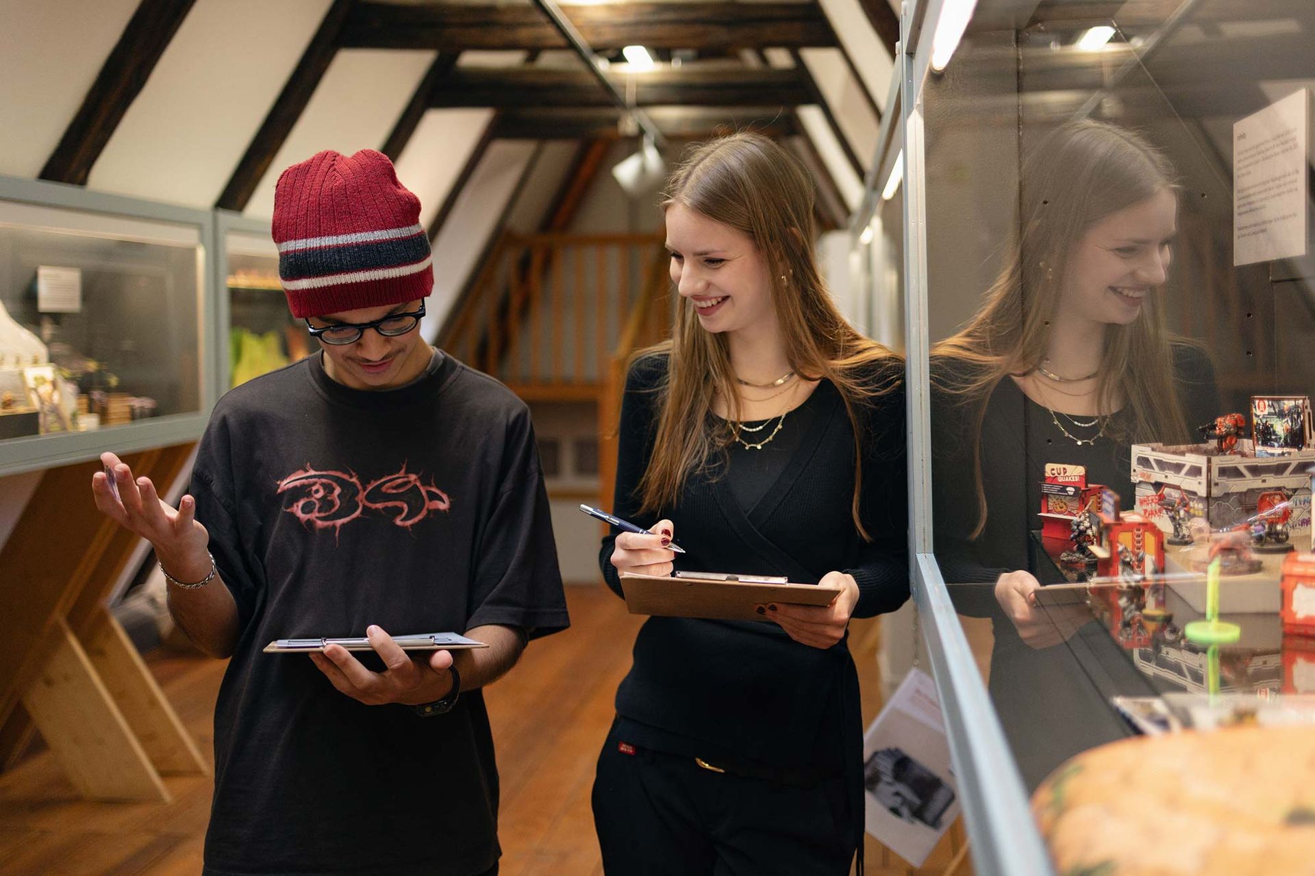 Ein Mann und eine Frau betrachten in einem Museum ein Klemmbrett.