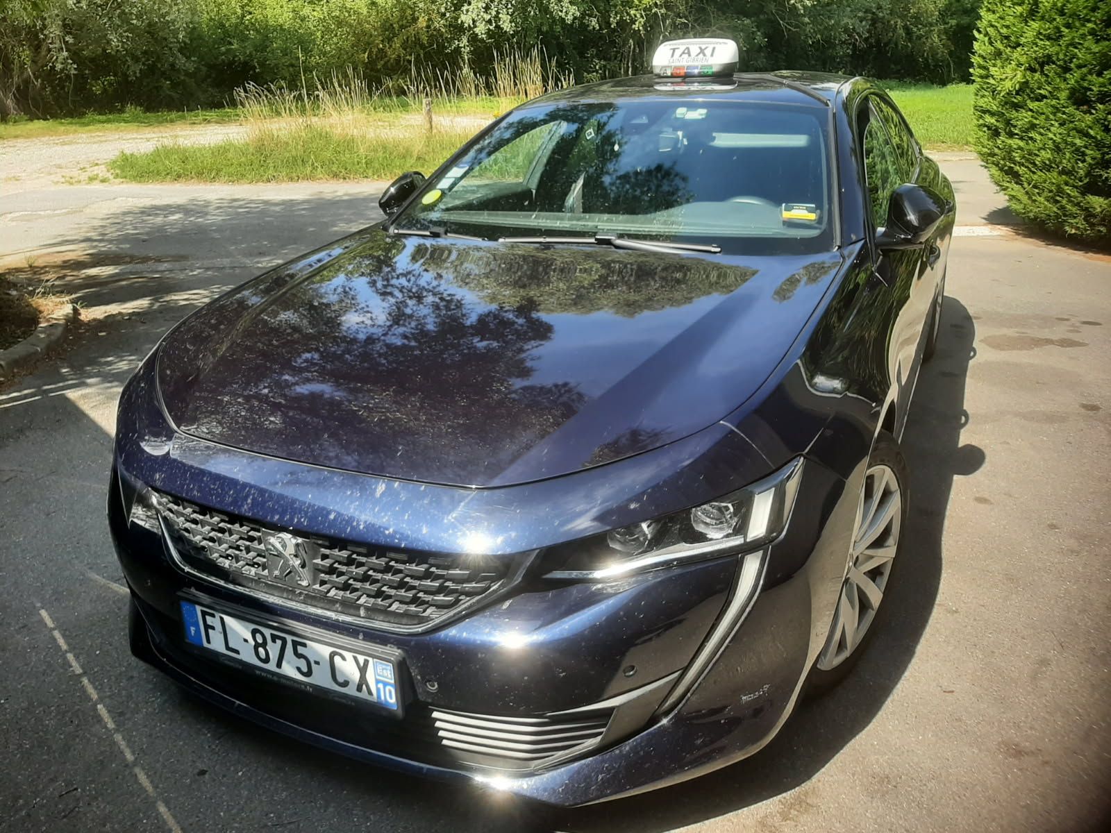 Taxi bleu foncé stationné à l'extérieur.