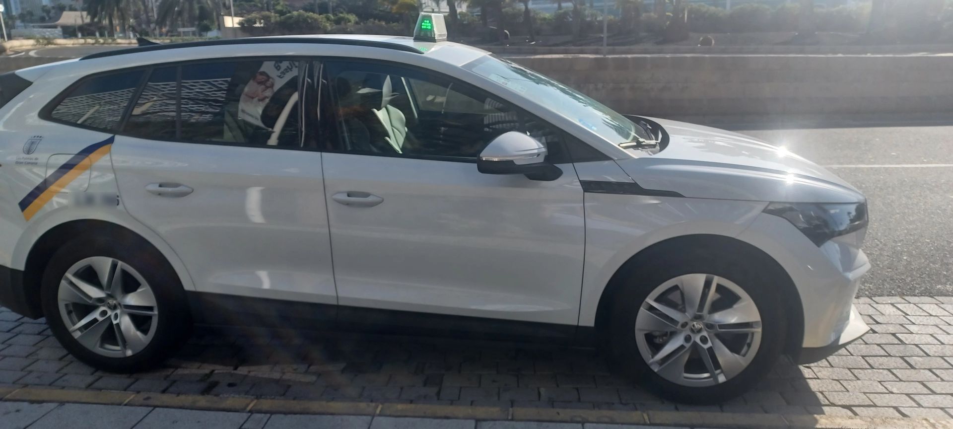Un coche blanco está estacionado al costado de la carretera.
