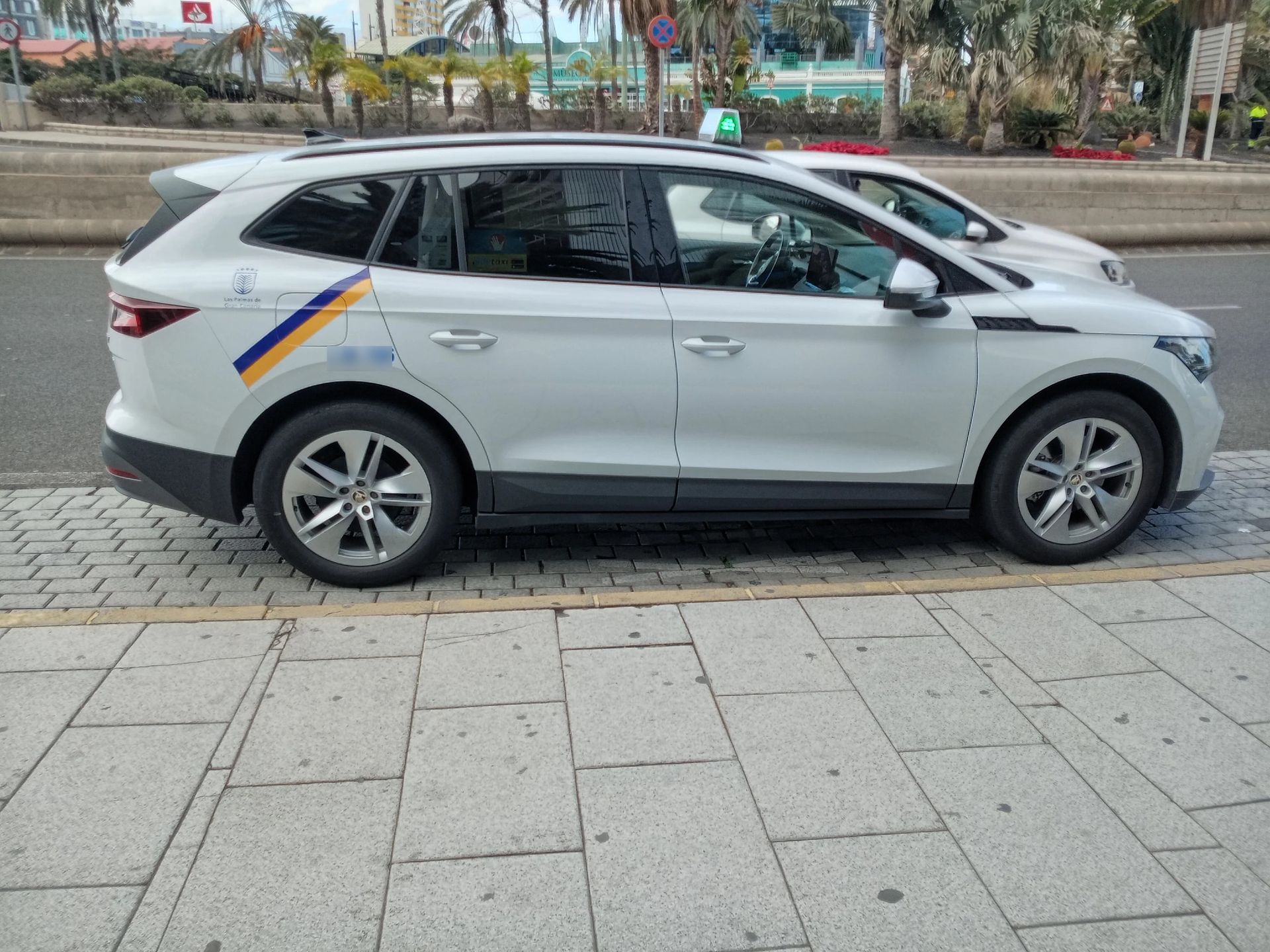 Un coche blanco está estacionado al costado de la carretera.