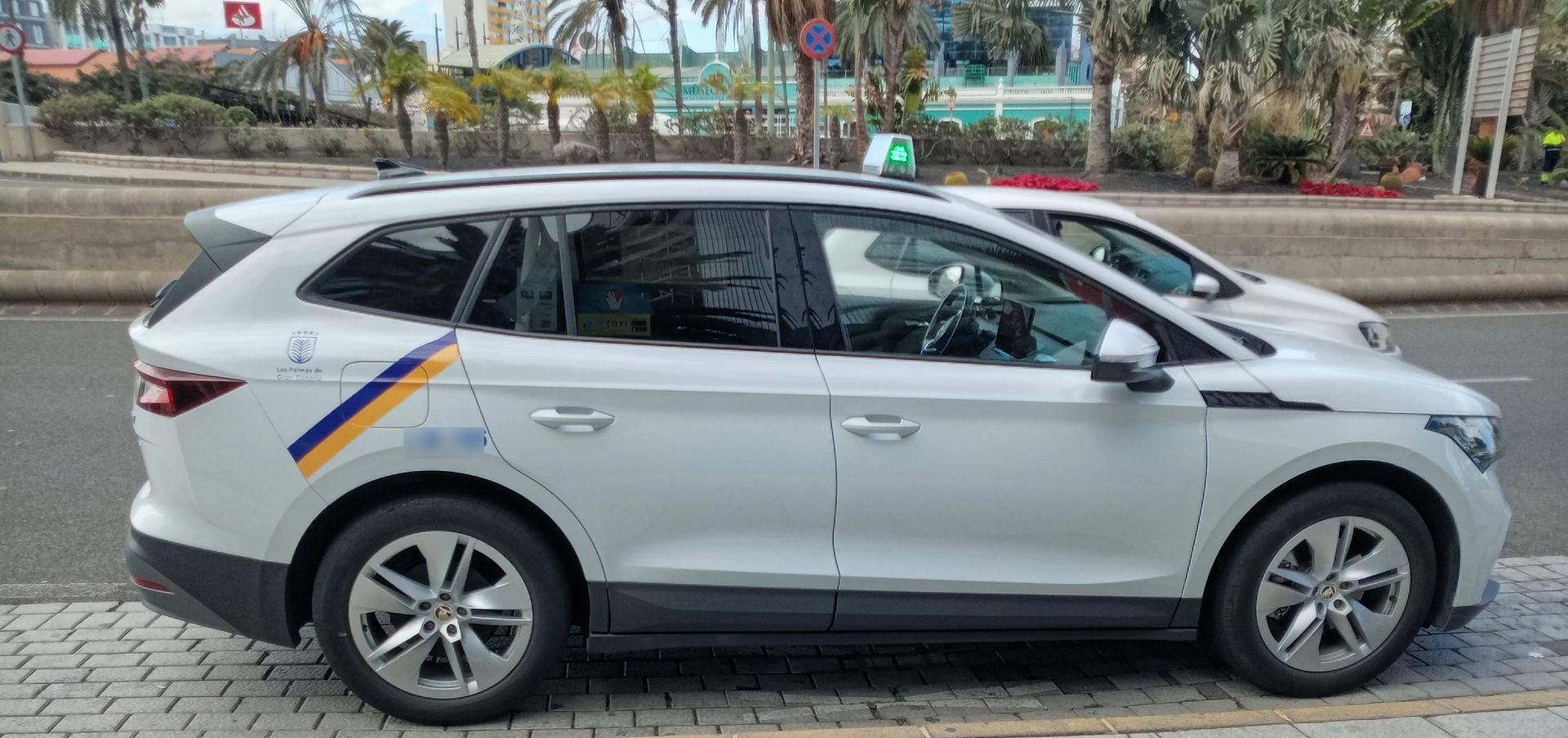 Un coche blanco está estacionado al costado de la carretera.
