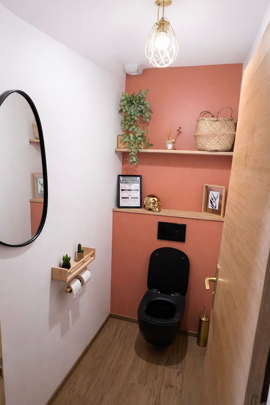 toilette moderne. toilette noir suspendu, étagère en bois au dessus décorer, miroir noir a gauche, mur blanc , fond de toilette terracotta 