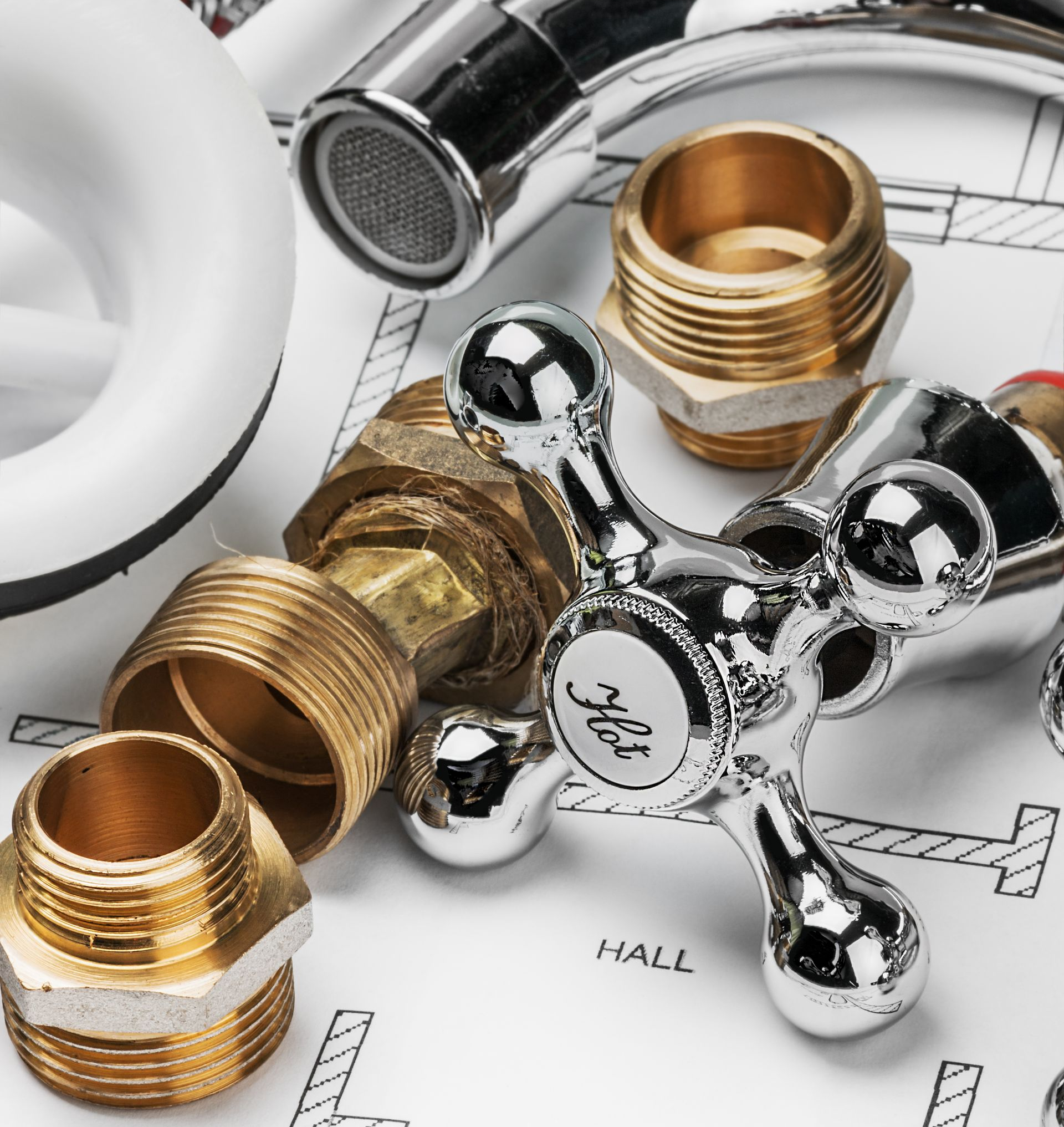 Outils et accessoires de plomberie disposés selon un plan. Comprend un robinet, des tuyaux et des raccords filetés en laiton et en chrome.