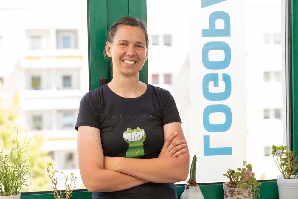 Eine Frau in einem schwarzen Poloshirt lächelt in die Kamera.