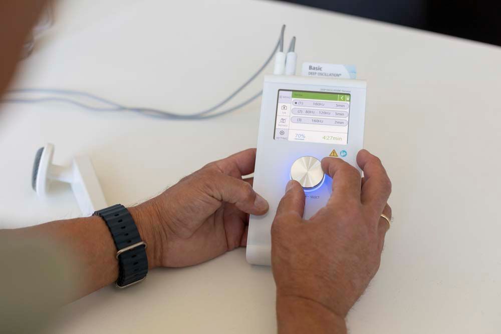 Eine Frau hält sich mit den Händen den Hals, weil sie Halsschmerzen hat.