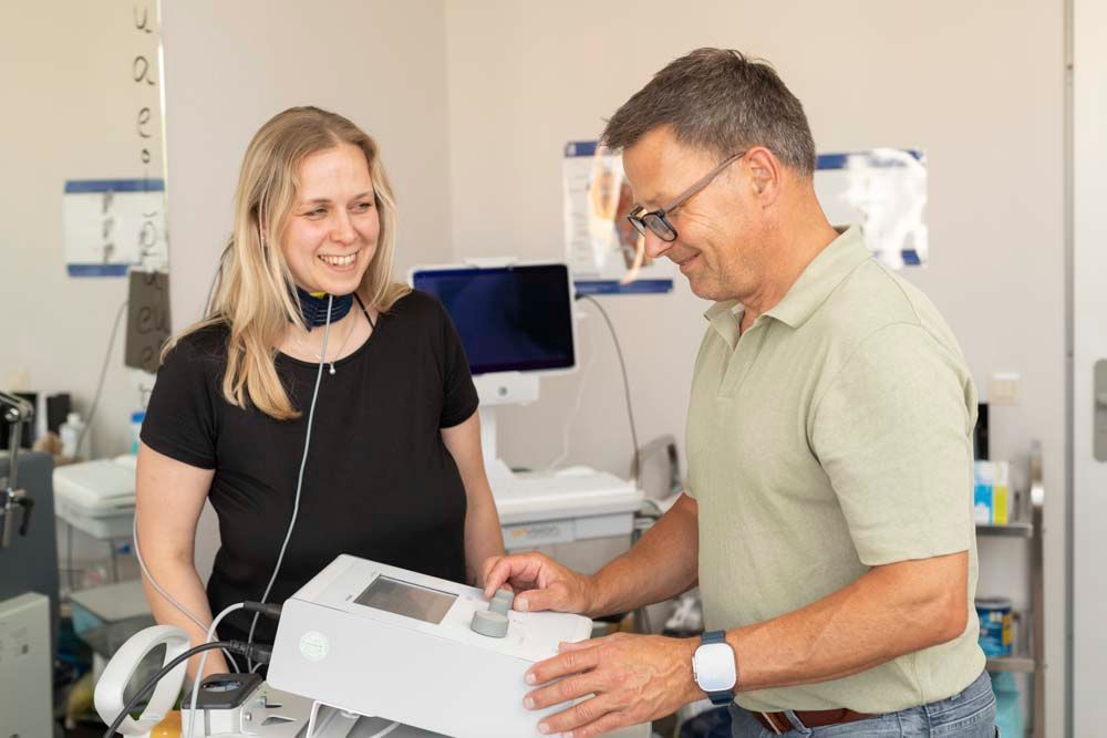 Eine Frau sitzt an einem Tisch und unterhält sich mit einem kleinen Jungen.