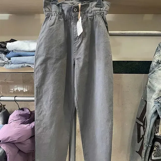 Un par de pantalones grises colgados en un perchero en un armario.