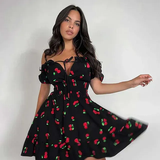 Una mujer con un vestido negro con cerezas.