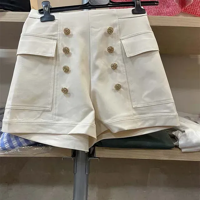 Un par de pantalones cortos blancos colgados en una percha en un estante.