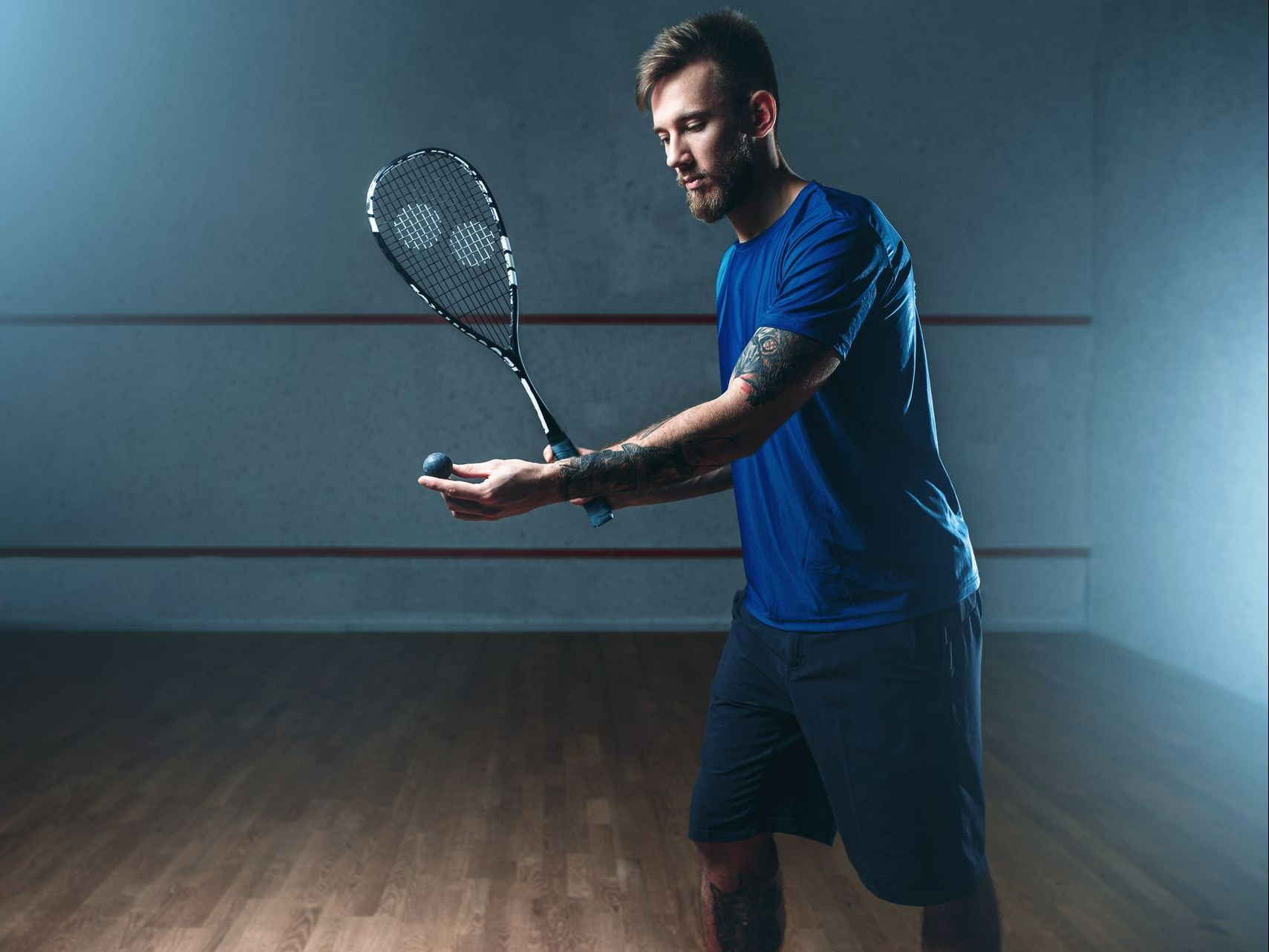 Un homme sur le point de taper une balle de squash