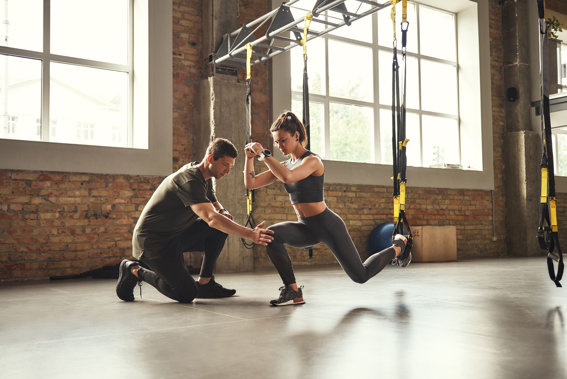 Un homme et une femme pratiquant le TRX