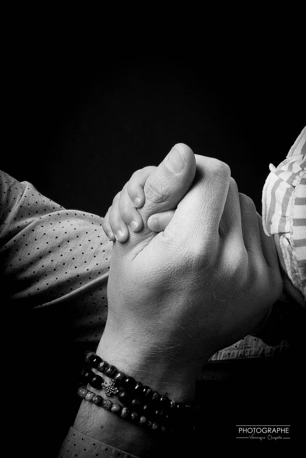 Photo en noir et blanc de 2 mains l'une dans l'autre