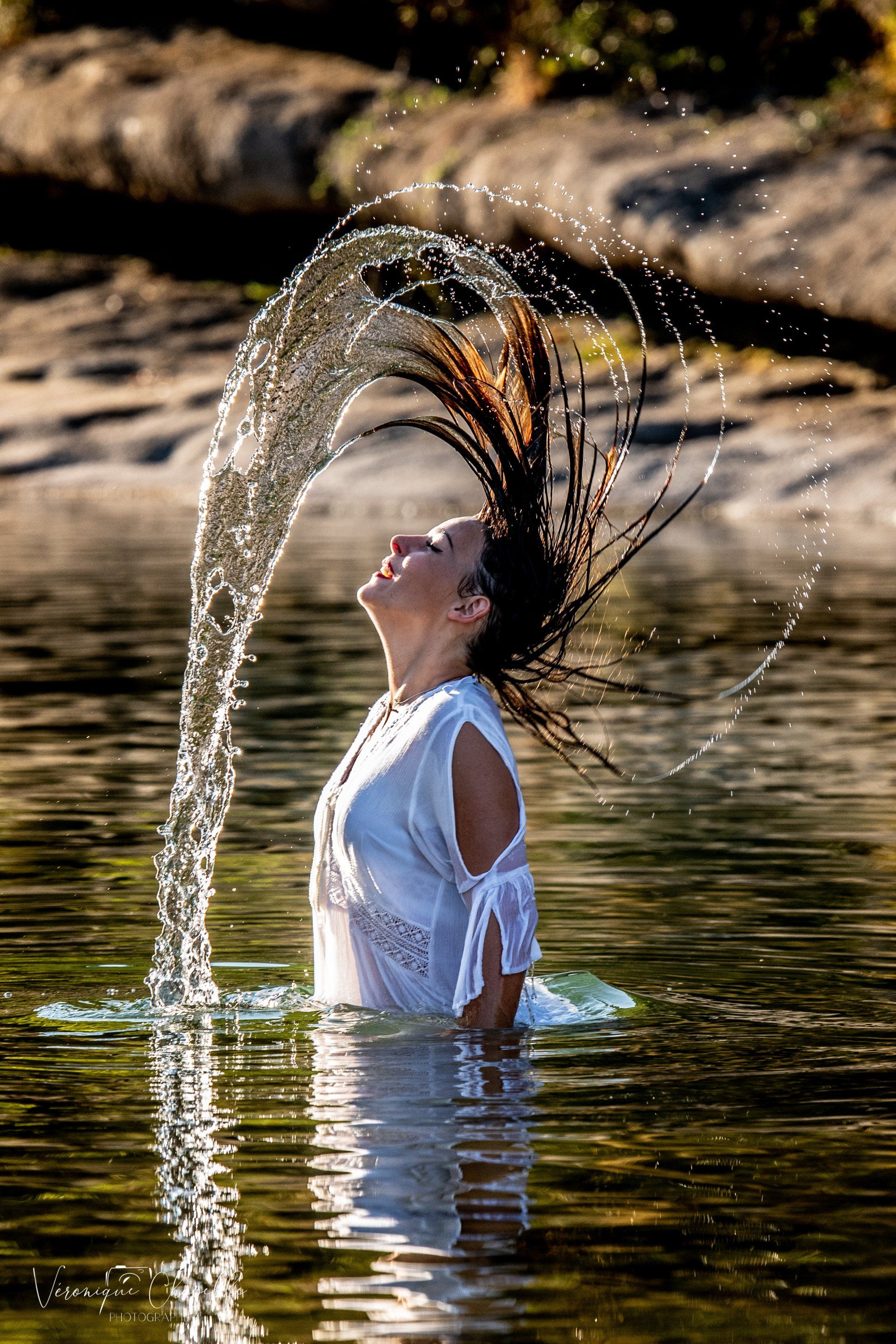 Portrait couleur d'une femme dans l'eau avec mouvement de cheveux