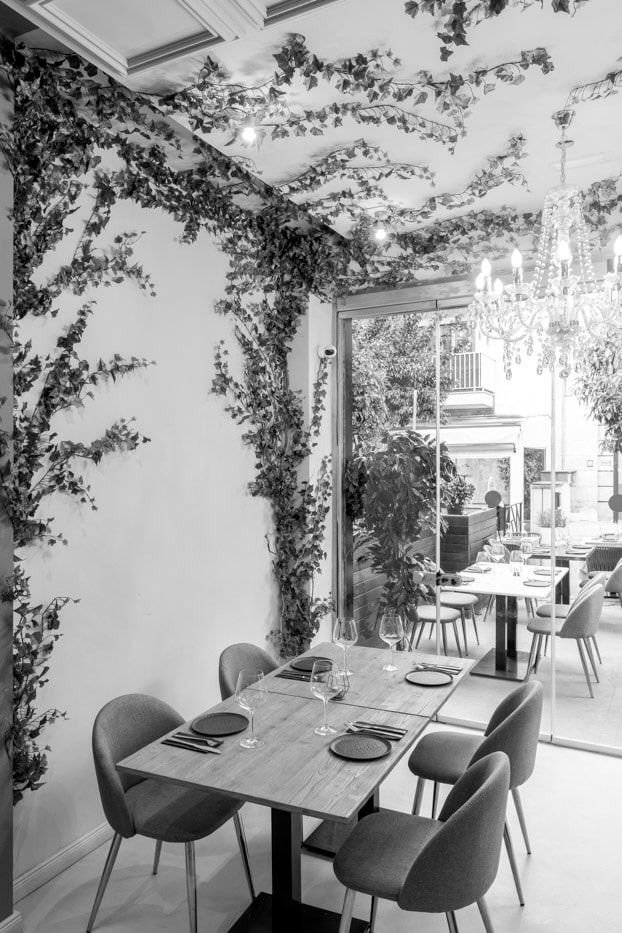 Una fotografía en blanco y negro de un restaurante con mesas y sillas.