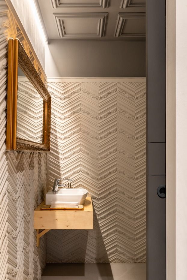 Un baño con un lavabo y un espejo en la pared.