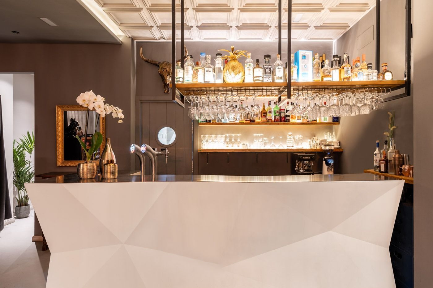 Un bar con muchas botellas y vasos encima.