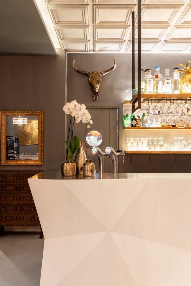 Un bar con una calavera de toro en la pared y un espejo.