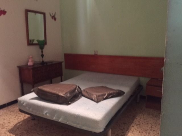 Un dormitorio con una cama y un espejo en la pared.