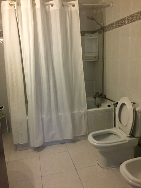 Un baño con inodoro, bañera, cortina de ducha y bidet.