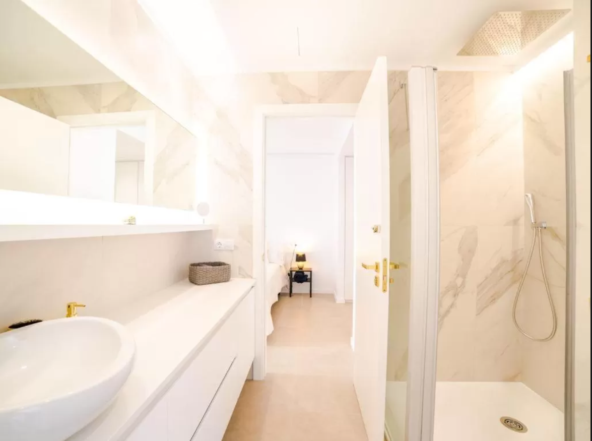 Un baño con lavabo y ducha a ras de suelo.