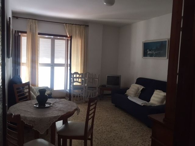 Una sala de estar con un sofá, una mesa y sillas.