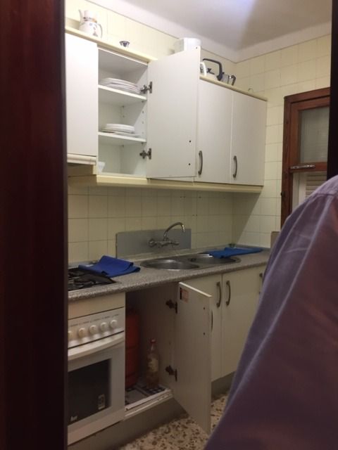 Una cocina con gabinetes blancos y un horno de estufa.