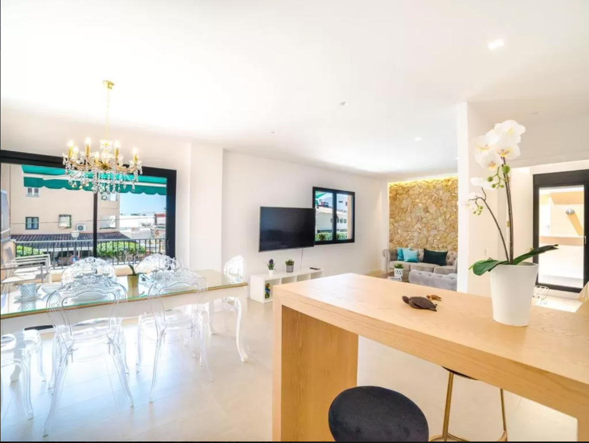 Una sala de estar con una mesa y sillas y un televisor de pantalla plana.