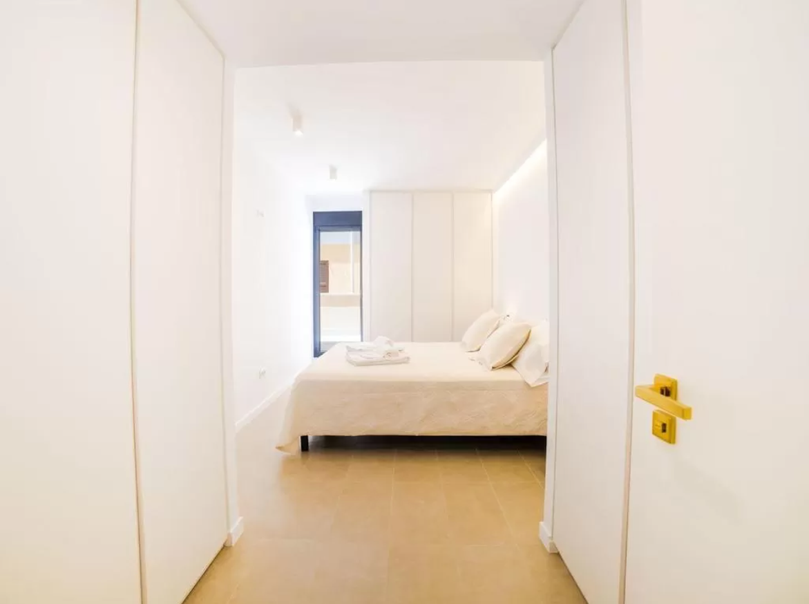 Un dormitorio con una cama y un pasillo que conduce a él.