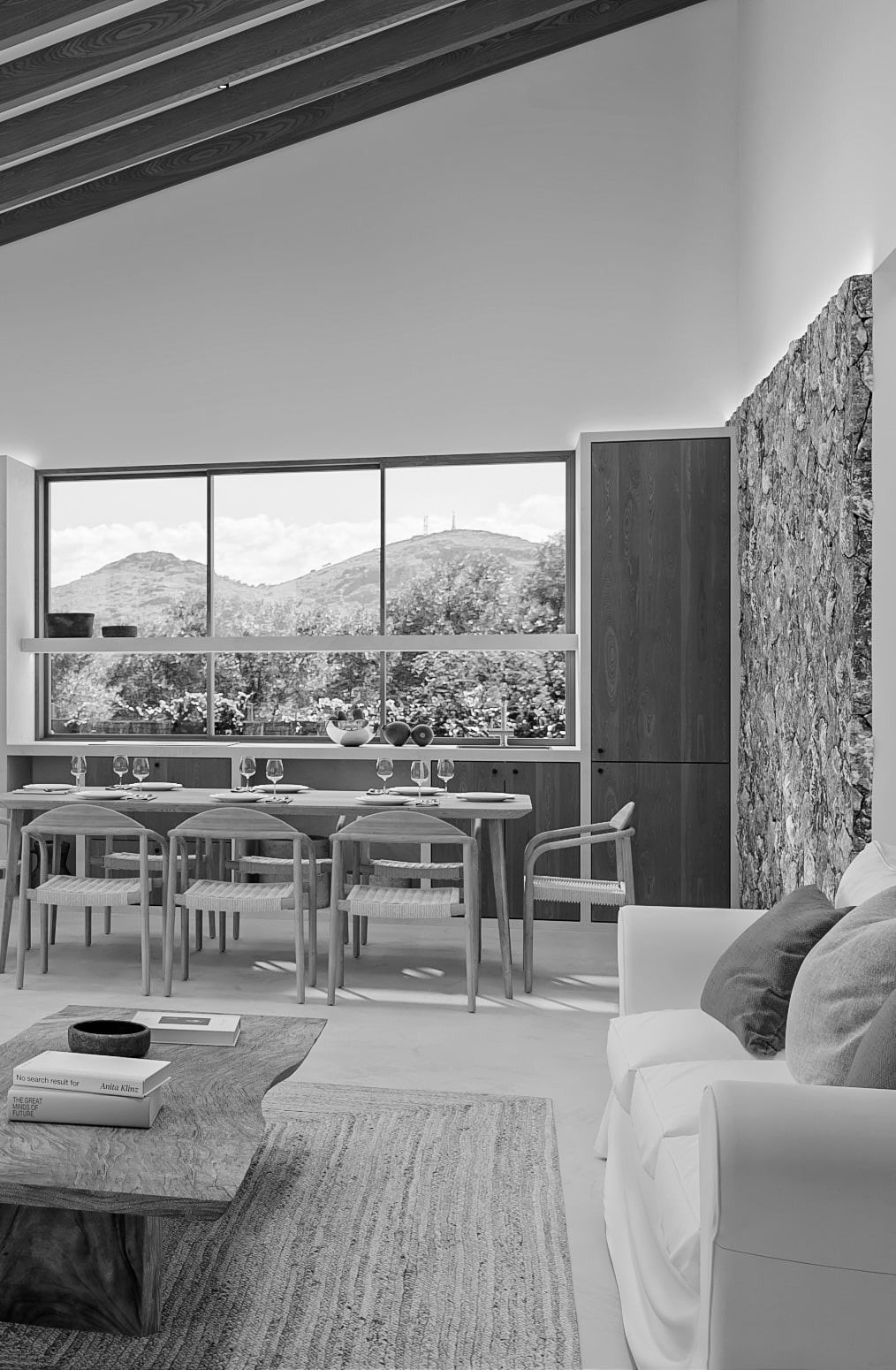 Una fotografía en blanco y negro de una sala de estar con un sofá, una mesa y sillas.