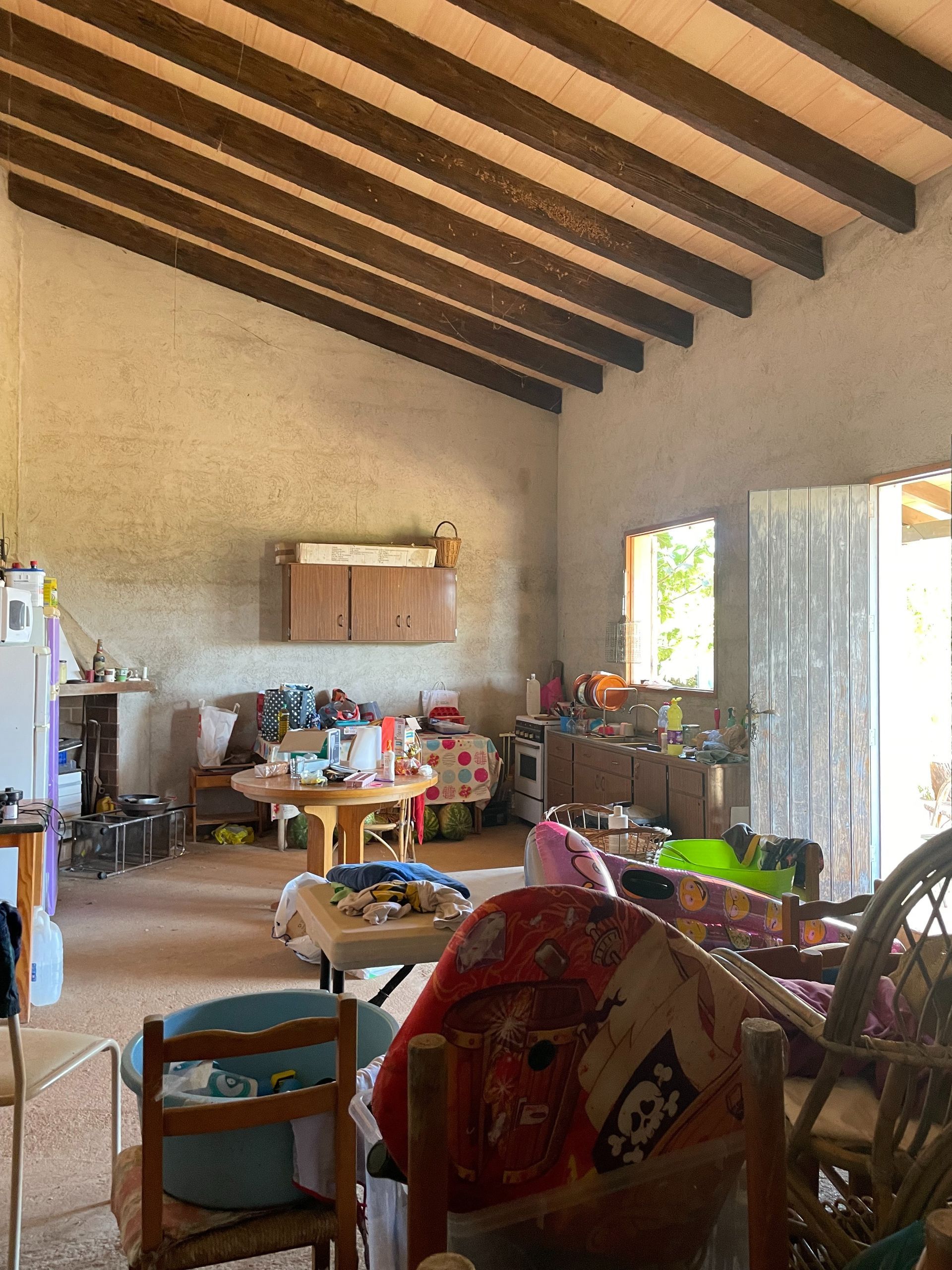 Una sala de estar con muchos muebles y una caja de juguetes en el suelo.