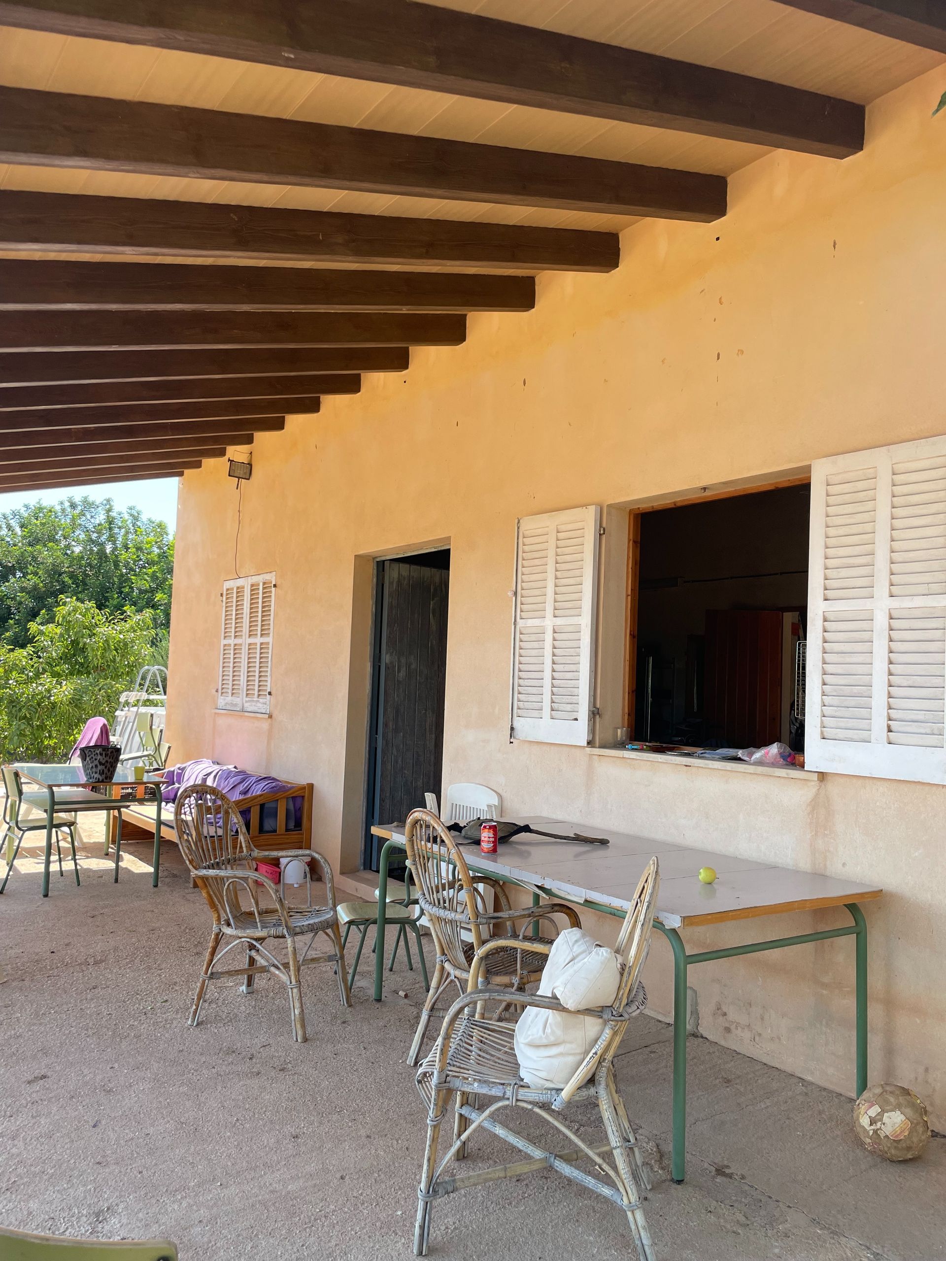 Un patio con mesas y sillas bajo un dosel.