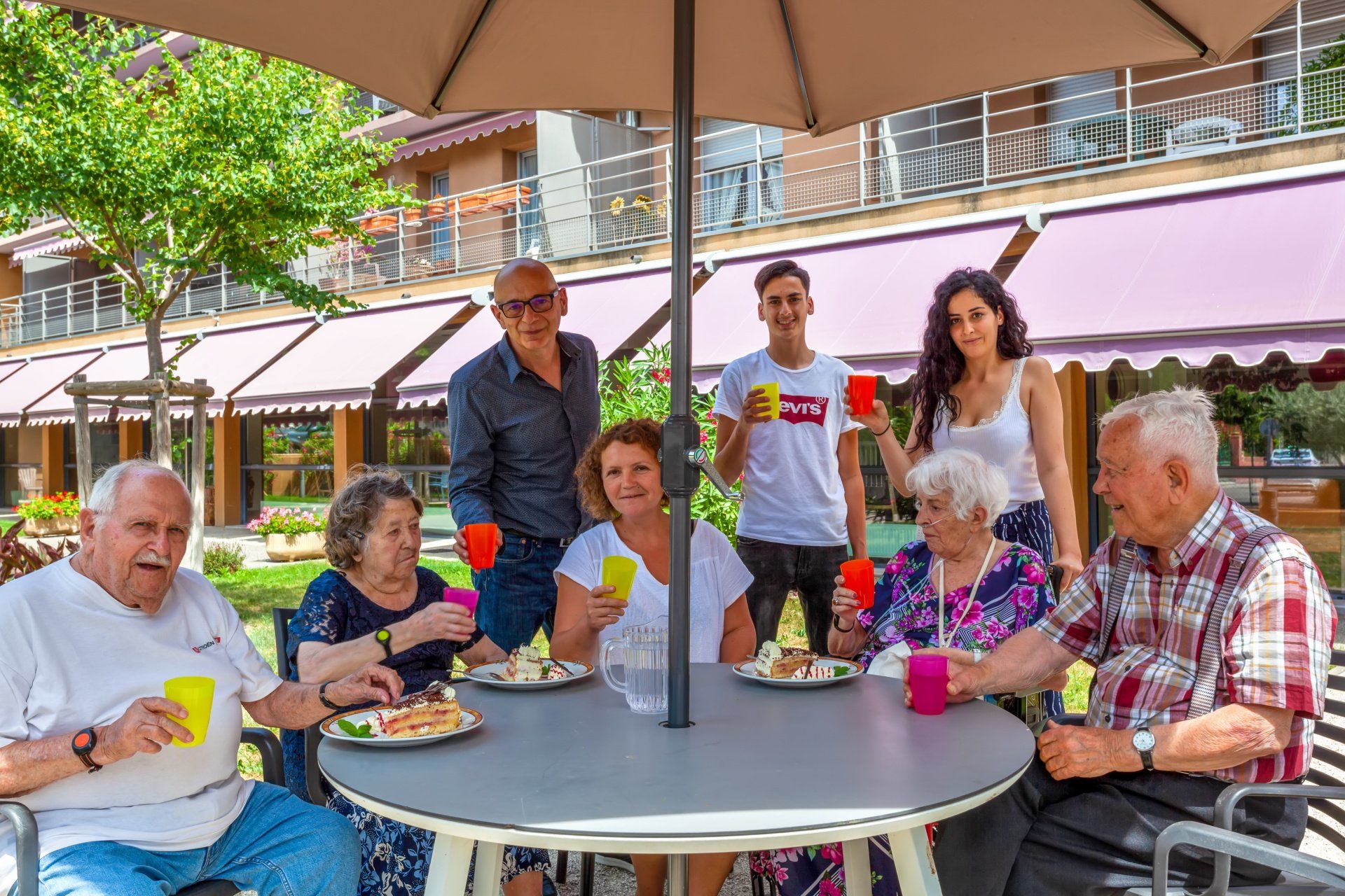 Plusieurs personnes de tous les âges trinquant autour d'une table