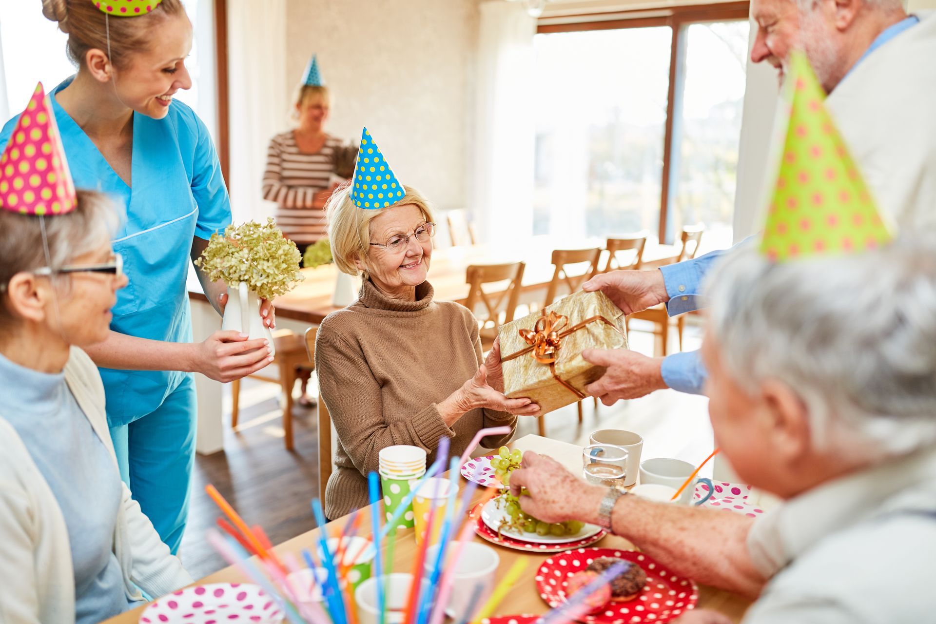 Personne âgée recevant un cadeau lors d'une fête d'anniversaire