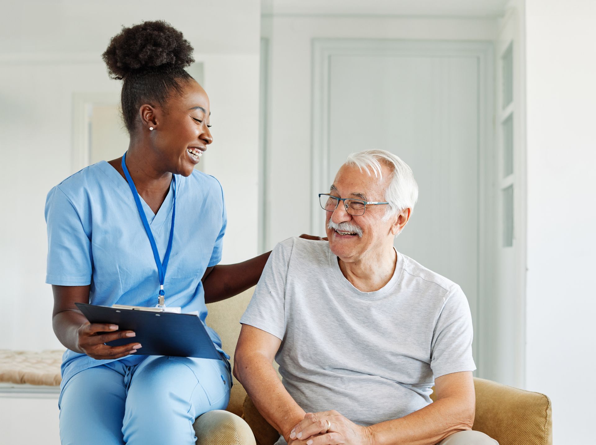 Aide-soignante qui discute avec un monsieur âgé