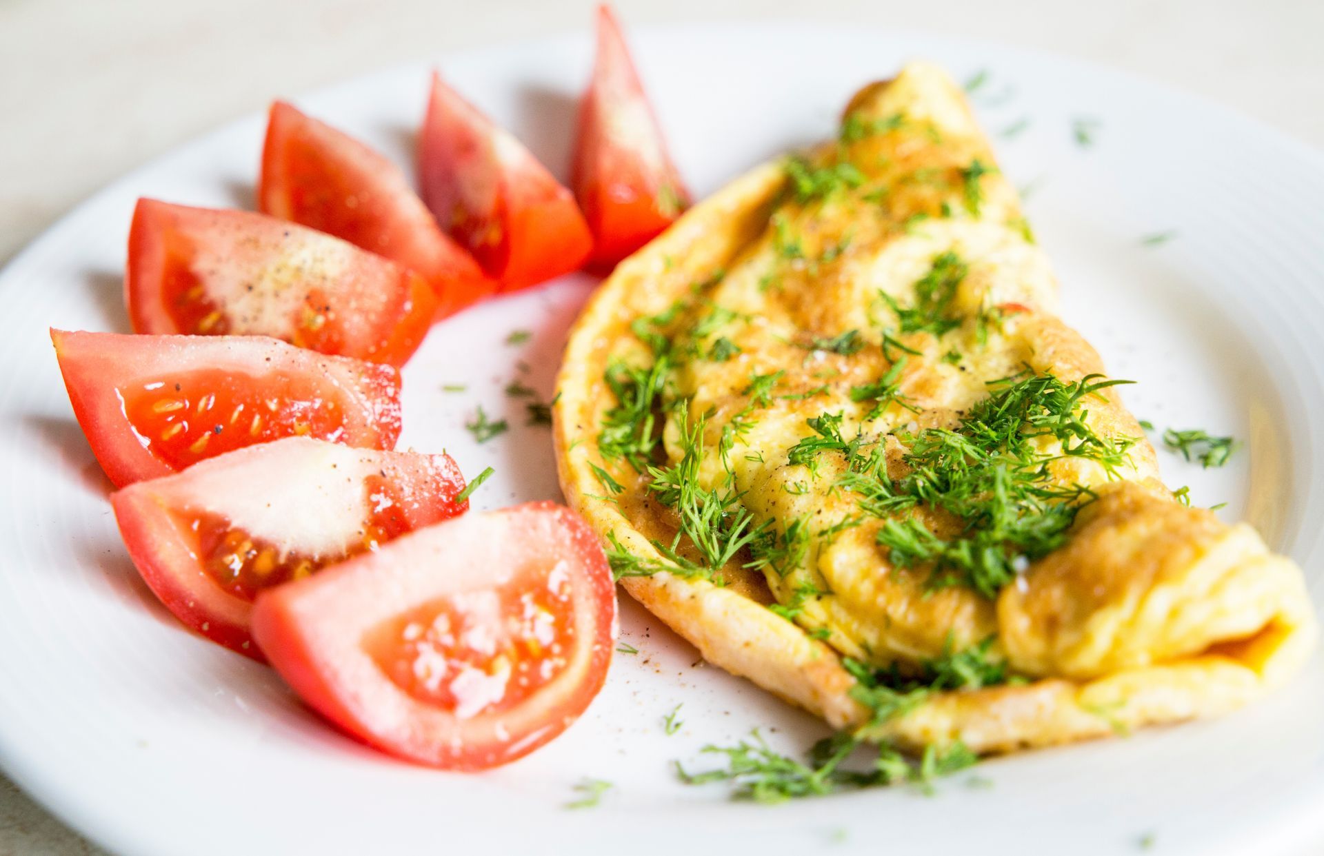 Assiette avec une omelette et des tomates coupées