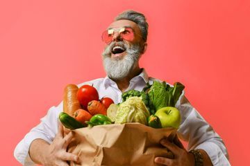 lachender Mann mit Gemüse