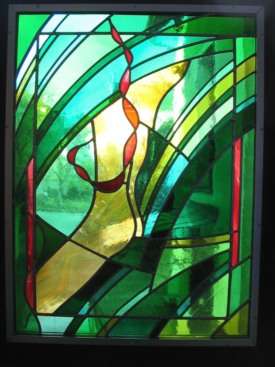 Fenster mit kunstvoller Bleiverglasung in Grün, Gelb und Orange