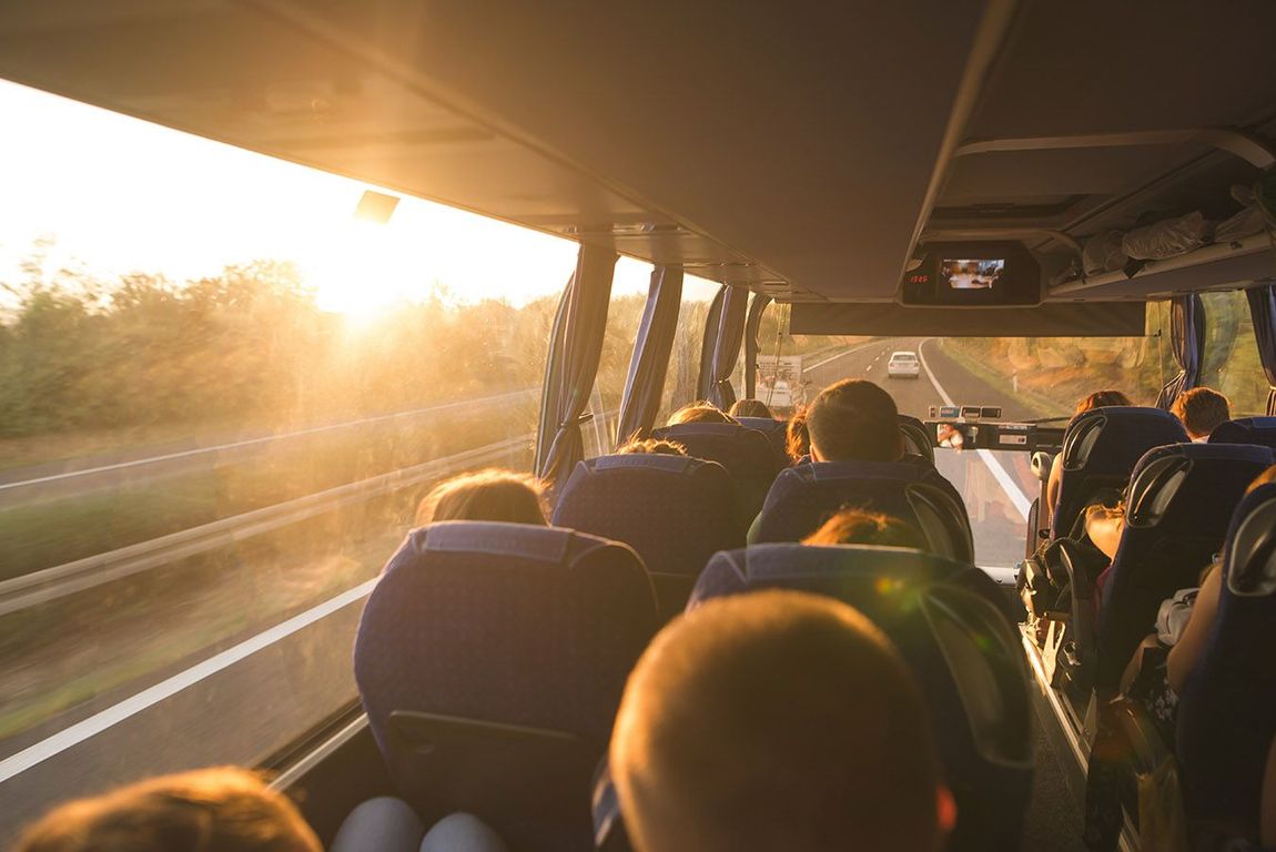 Eine Gruppe von Menschen fährt in einem Bus auf einer Autobahn.