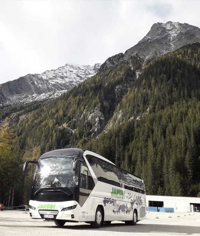 Ein weißer Bus steht vor einem Berg