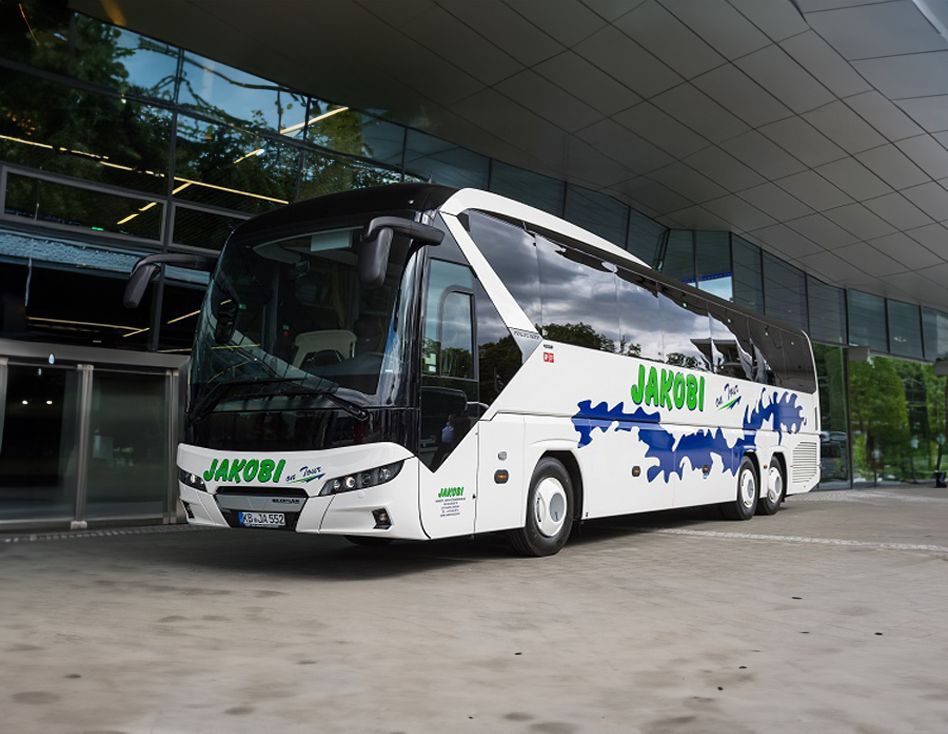 Ein weiß-schwarzer Bus parkt vor einem Gebäude.